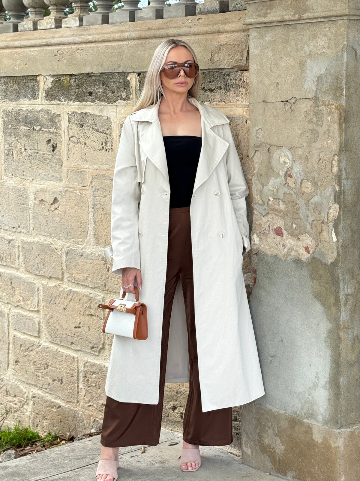 The Amélie trench coat in stone, worn open, full-length front view