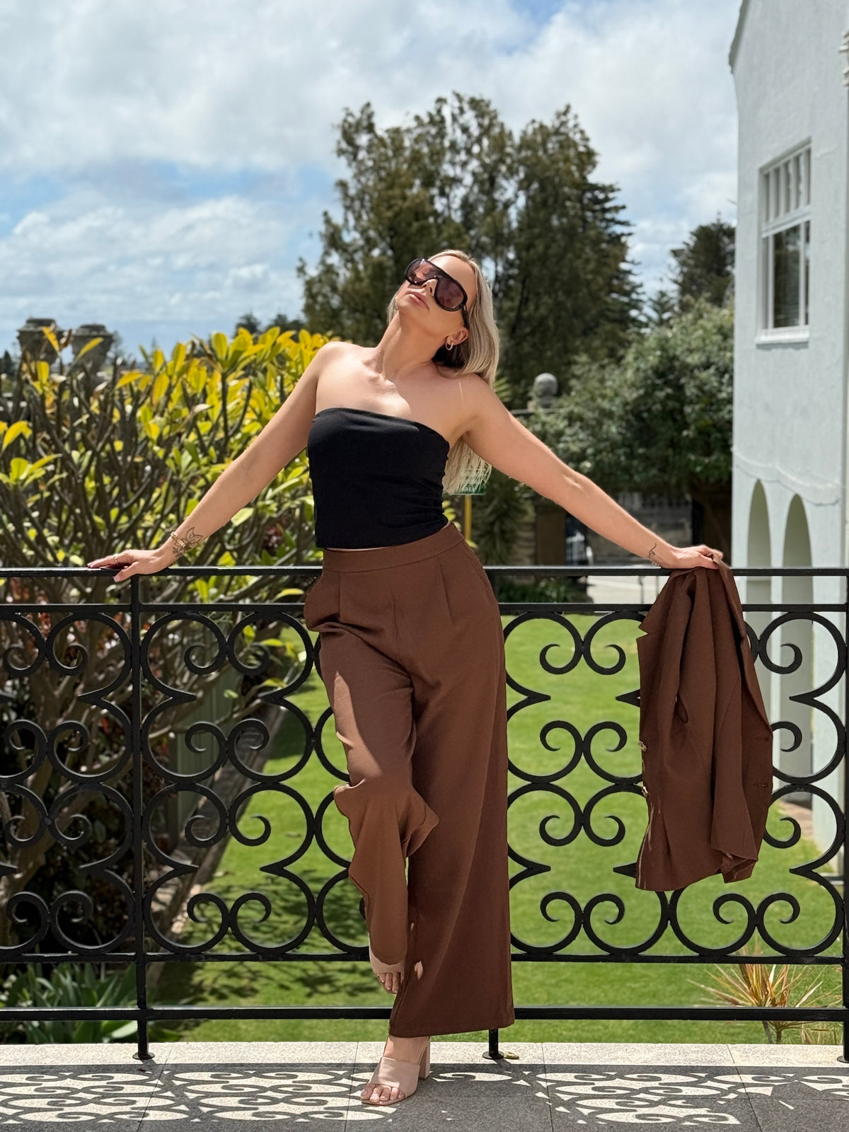 The Margaux wide leg trousers in chocolate, with the vest held in hand
